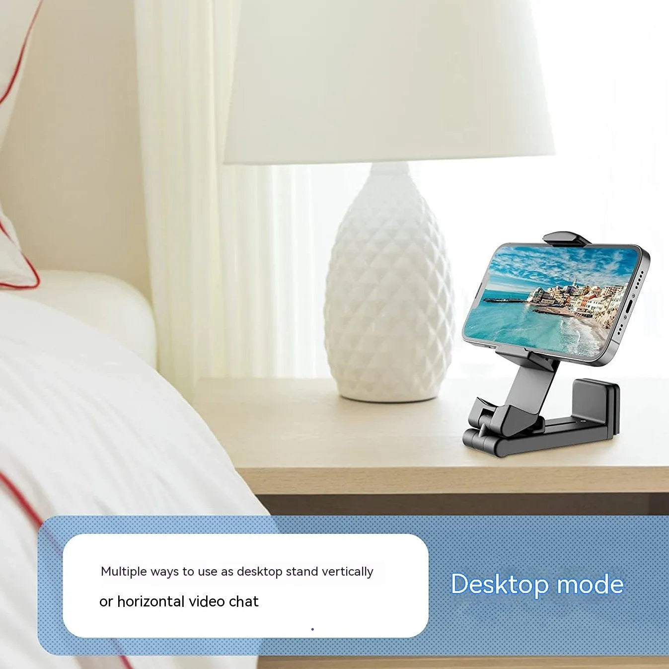 Black foldable rotating phone holder holding a mobile phone upright on a desk.