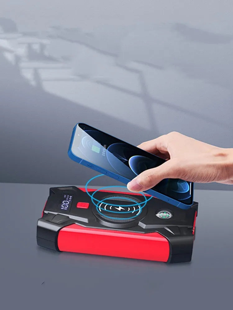 Red portable car jump starter with thick clips and digital display for emergency vehicle battery boosting