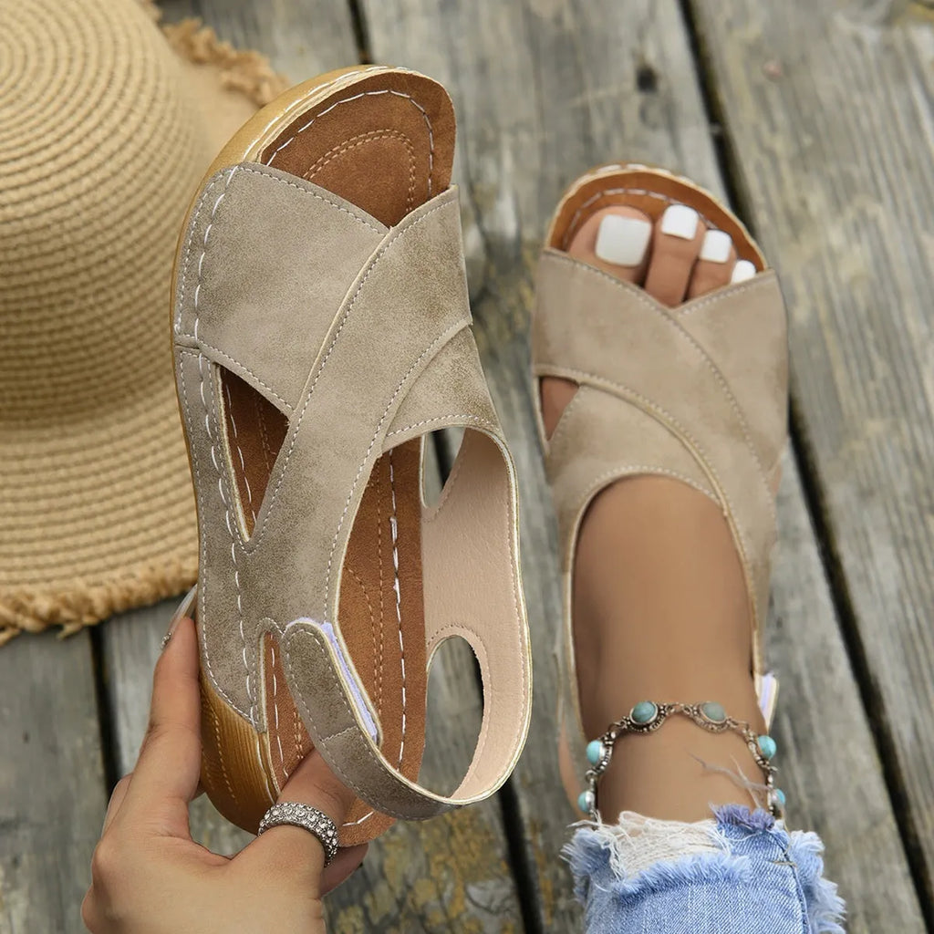 Women's brown platform Roman sandals with Velcro strap and open toe on a rubber sole.