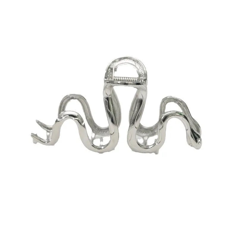 Silver metal Slytherin serpentine hair clip barrette measuring 10.5cm on a dark background