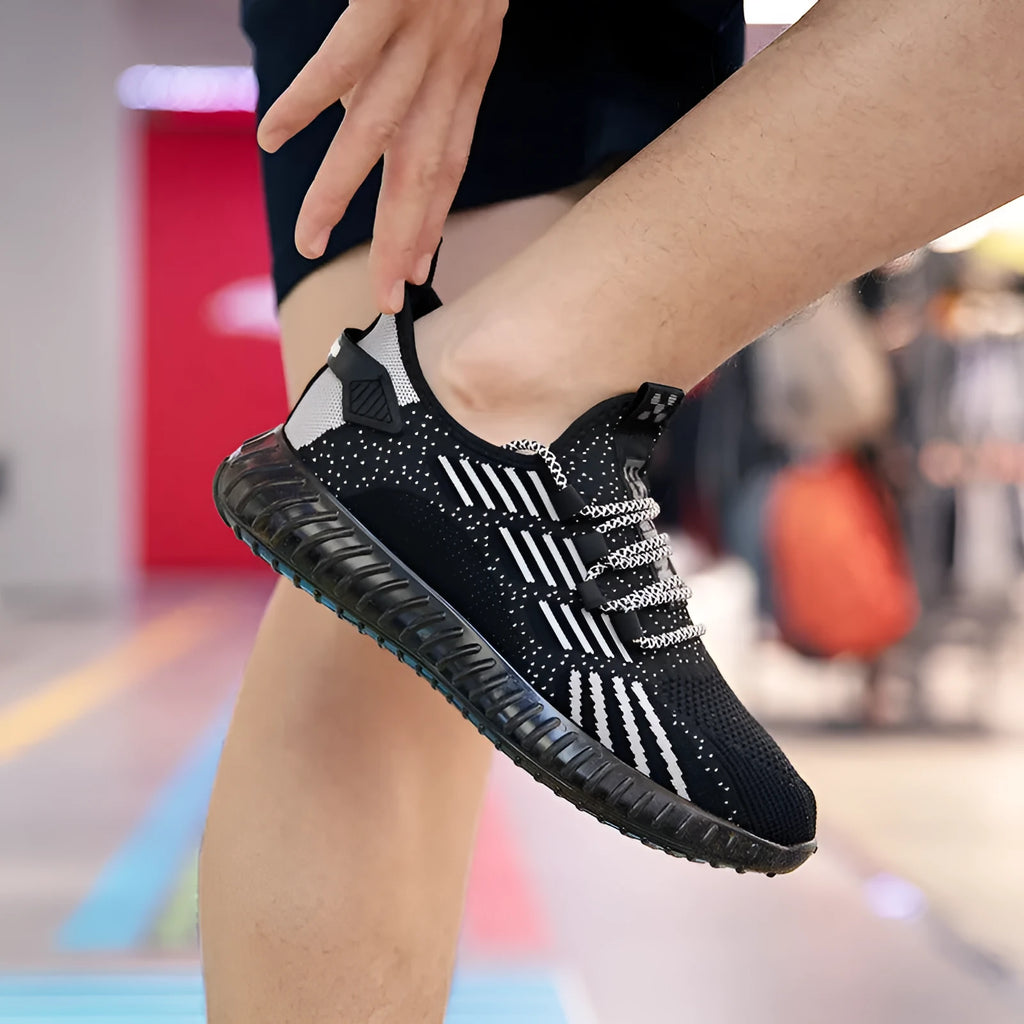 Men's white breathable flying fabric sports shoes with round toe and flat heel on a model.
