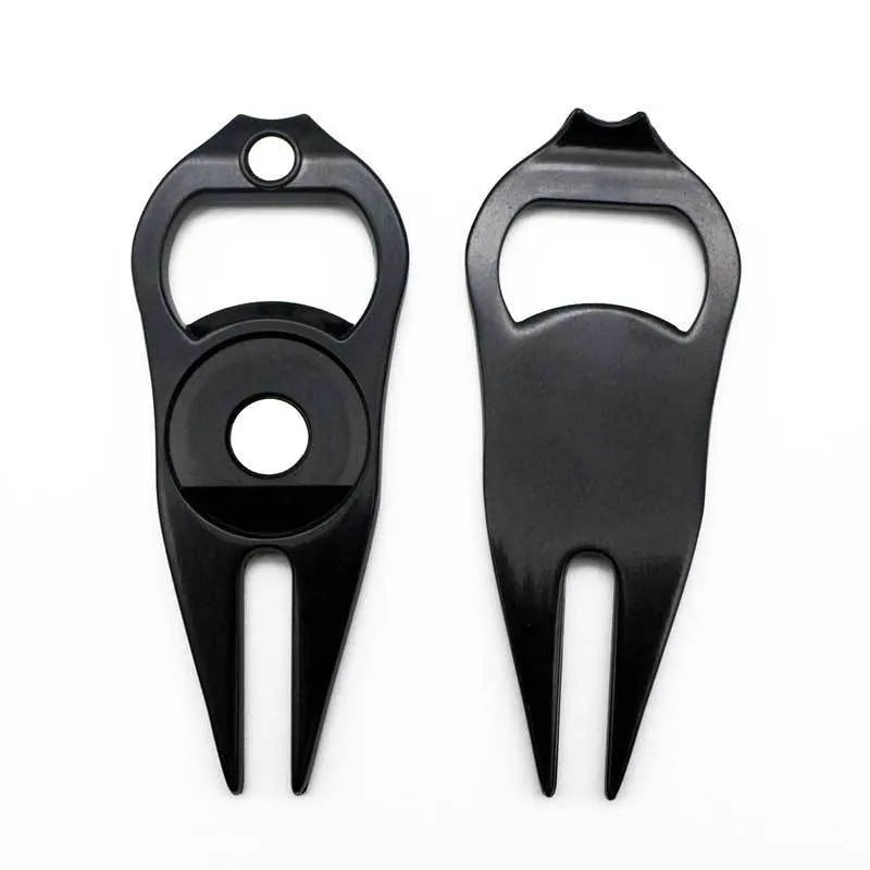 Black zinc alloy golf ball fork and bottle opener tool on green turf
