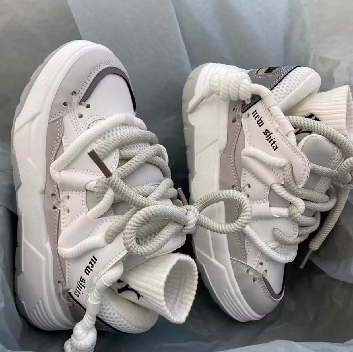 Women's thick bottom grey retro clunky sneakers with high heel on a white background.