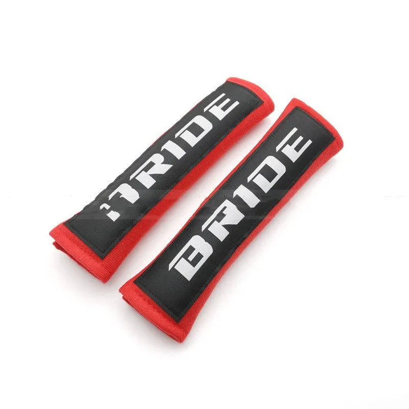 Pair of black car seatbelt shoulder pads with embroidered texture, showing dimensions.