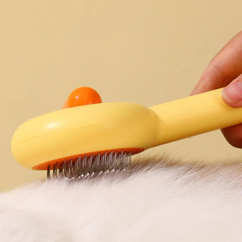 Small yellow duck-shaped pet grooming comb with open section and needle teeth