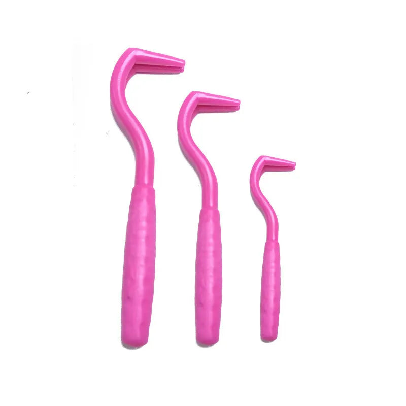 Set of three coloured plastic tick removal hooks for pets on a white background.