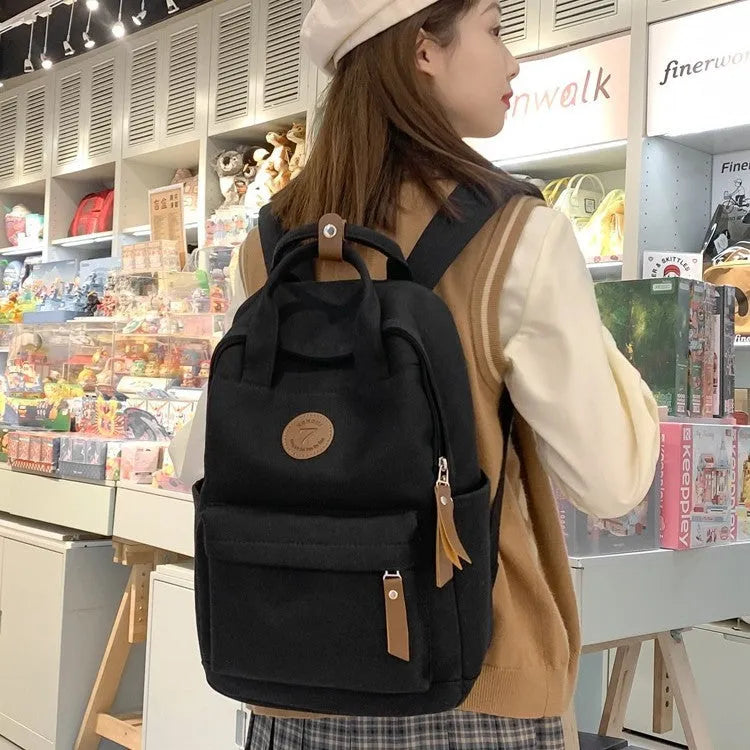 Black Oxford cloth backpack with curved shoulder straps for school and travel use