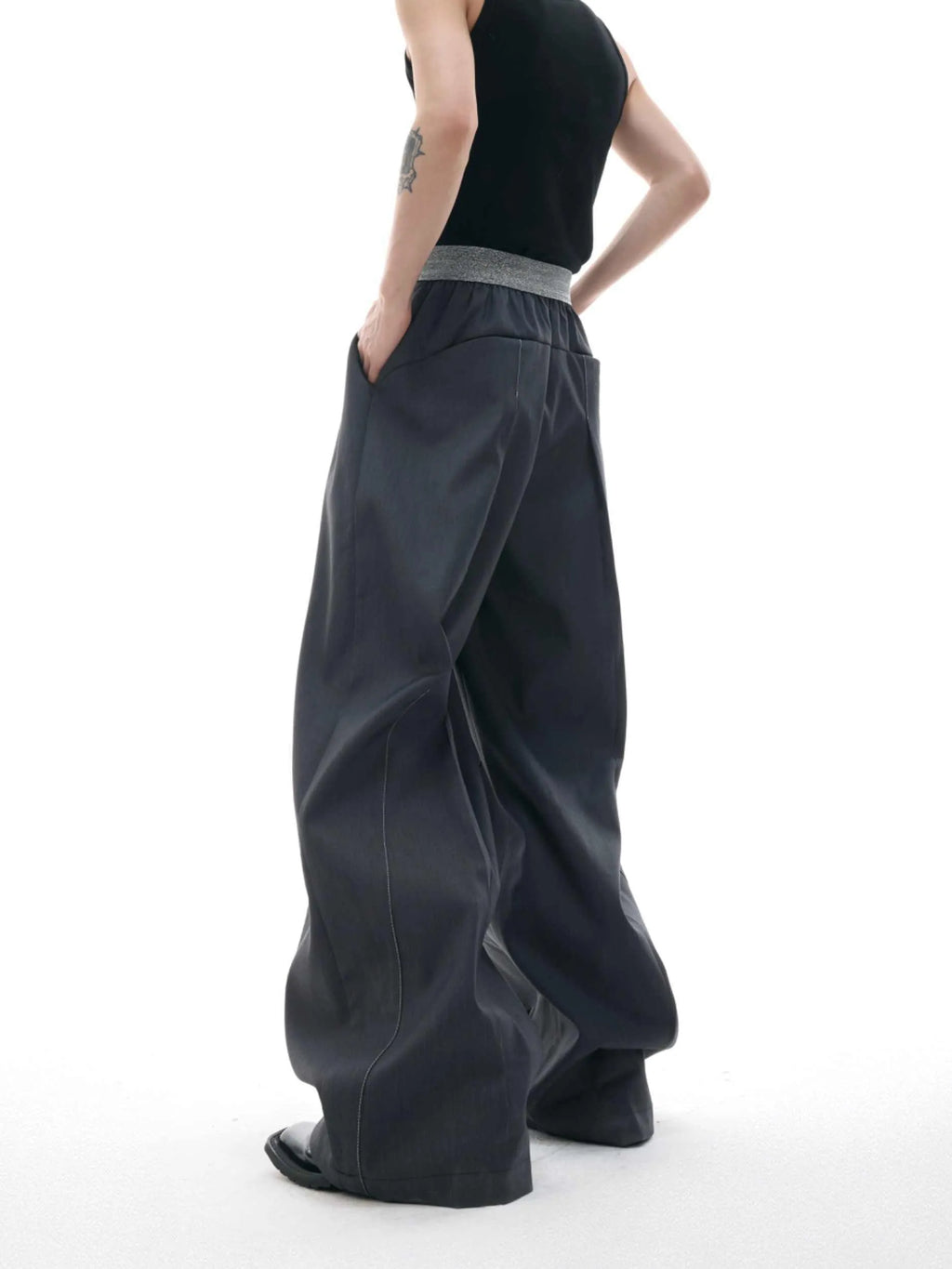 Men's grey straight-leg high-waisted trousers with a button-fly opening on a neutral background.