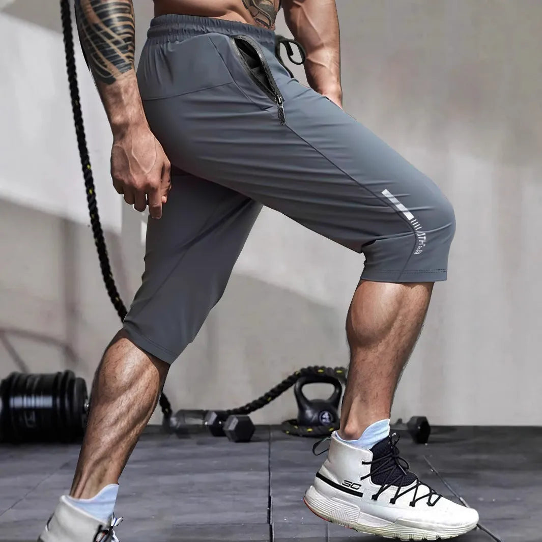 Man wearing black cropped straight-leg sports casual pants made from quick-drying nylon fabric.