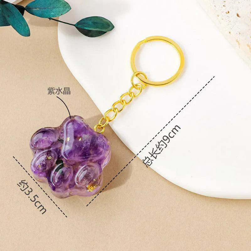 Natural crystal cat's paw shaped pendant on a silver keychain ring, shown in a random colour.