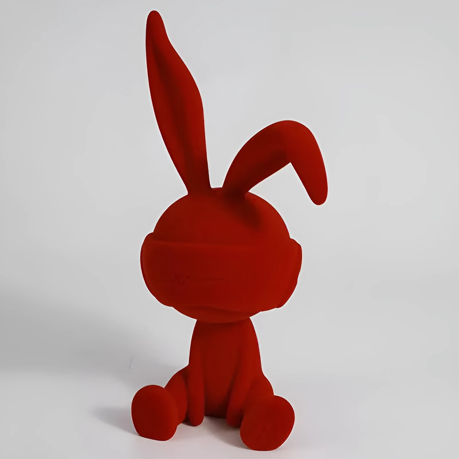 Green suede blindfold rabbit resin table ornament on wooden surface