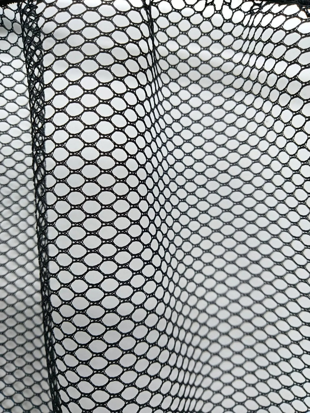 Elastic car boot storage net organiser holding various loose items securely in place
