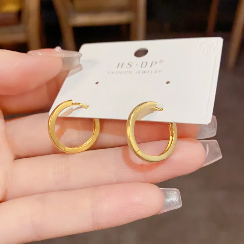 Women's geometric eyelet ear clip in gold or silver colour with round elements on copper base