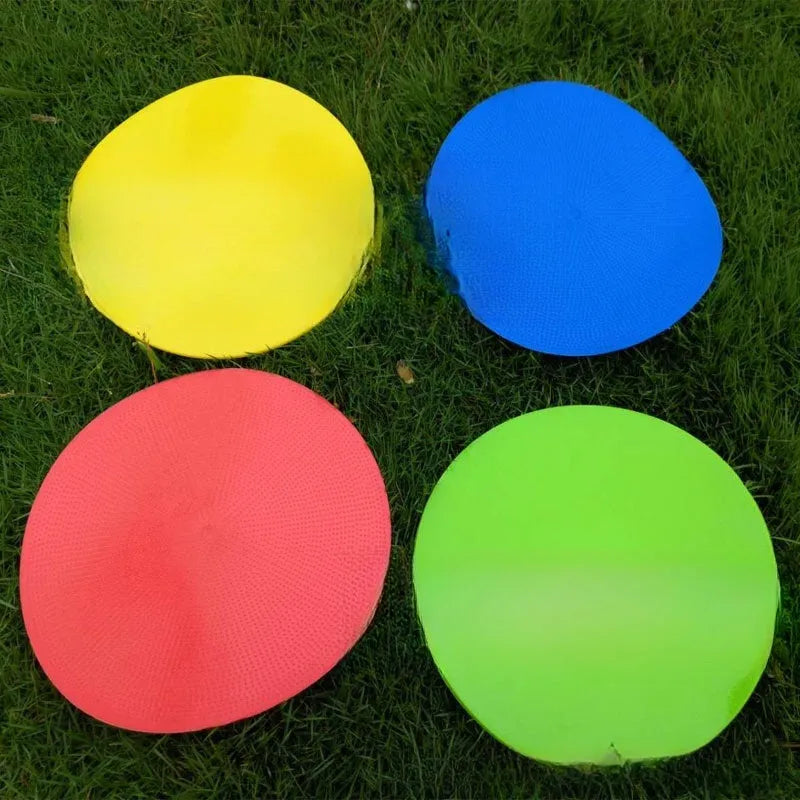 Flat, round yellow football training target disc with 23cm diameter on grass.