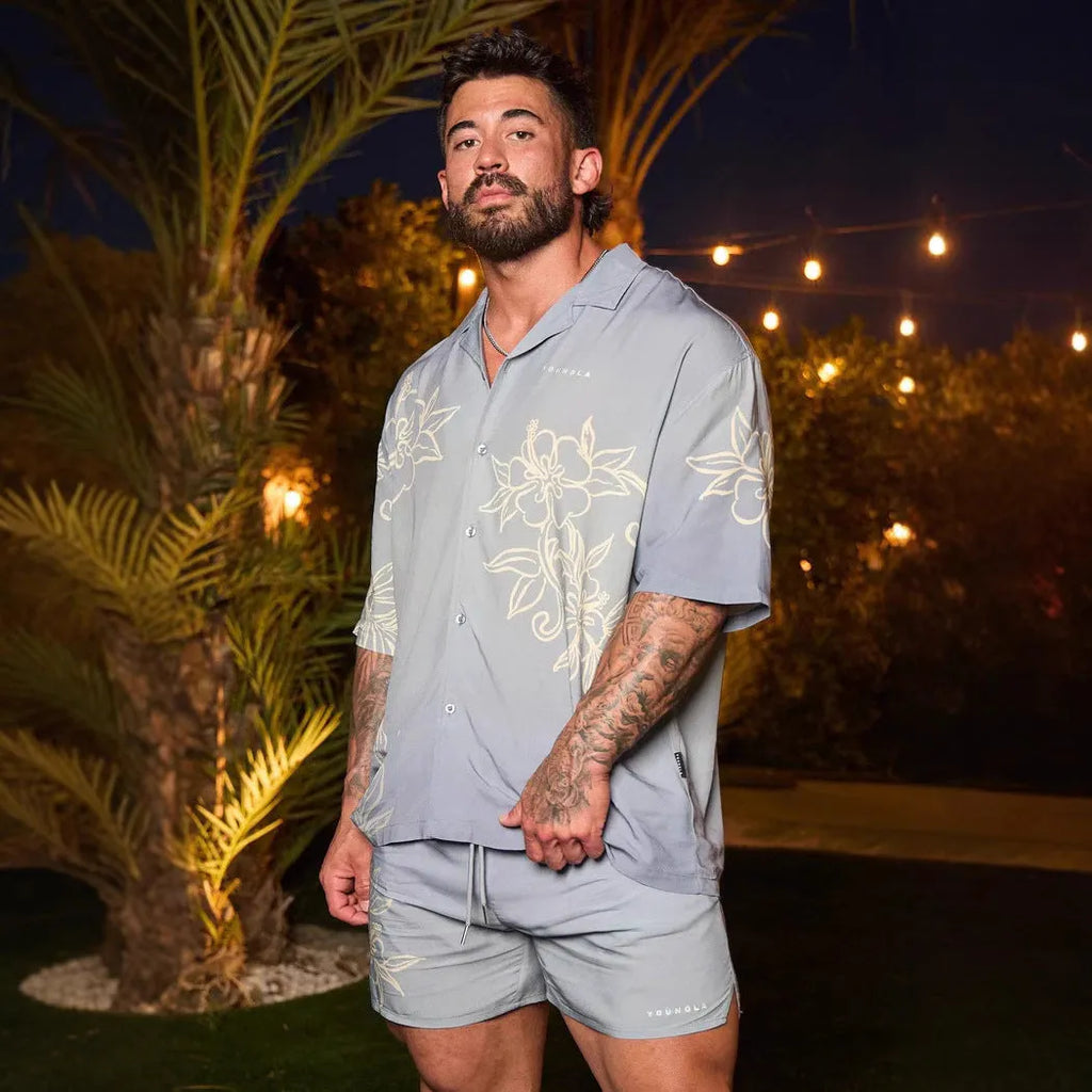 Man wearing a loose-fit, short sleeve floral print top in a neutral colour.
