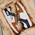 A pair of plain white and blue lace-up casual sneakers on a simple background.