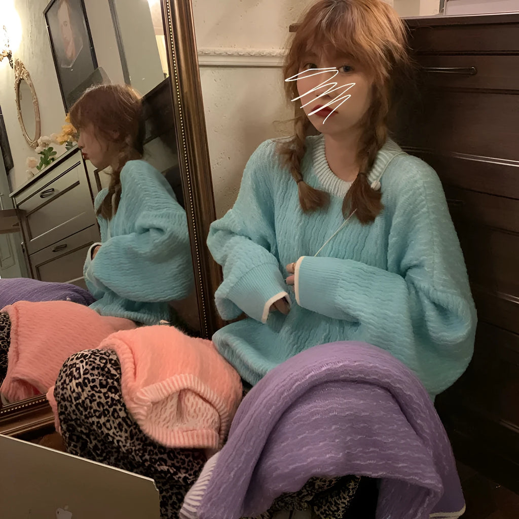A woman's loose-fitting solid colour retro pullover sweater in lake blue, shown on a hanger.