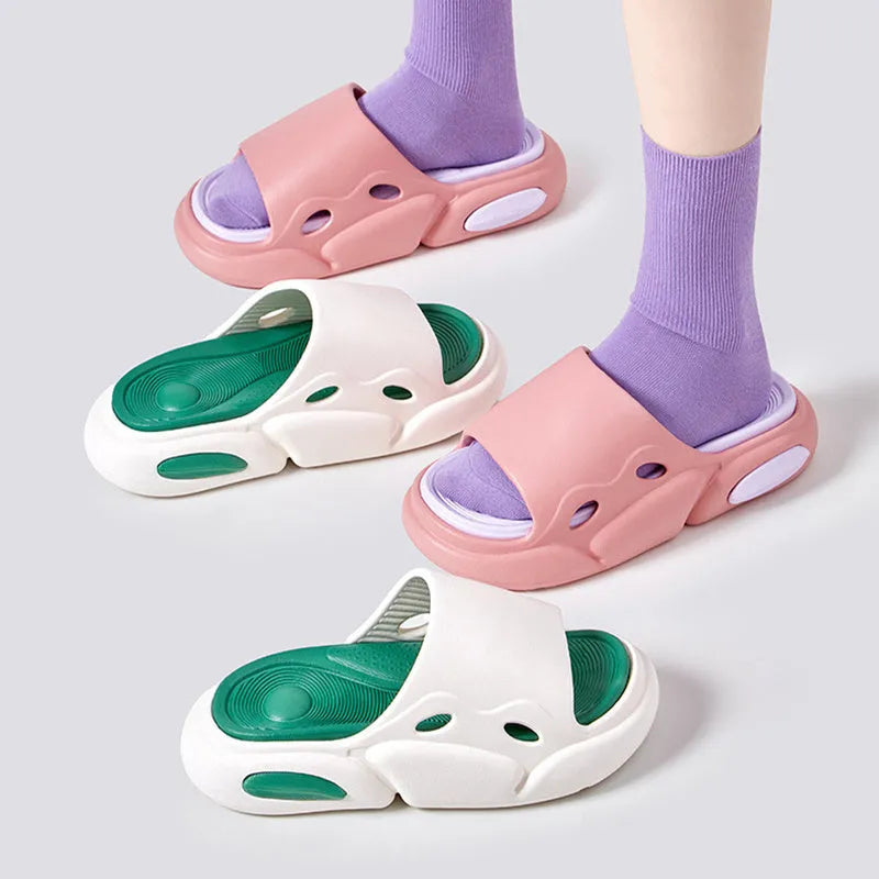 Two-colour EVA slippers for couples in pink and purple, shown on a wooden floor.