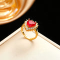 Women's heart-shaped jewellery set with matching necklace, stud earrings, and ring in electroplated gold red finish