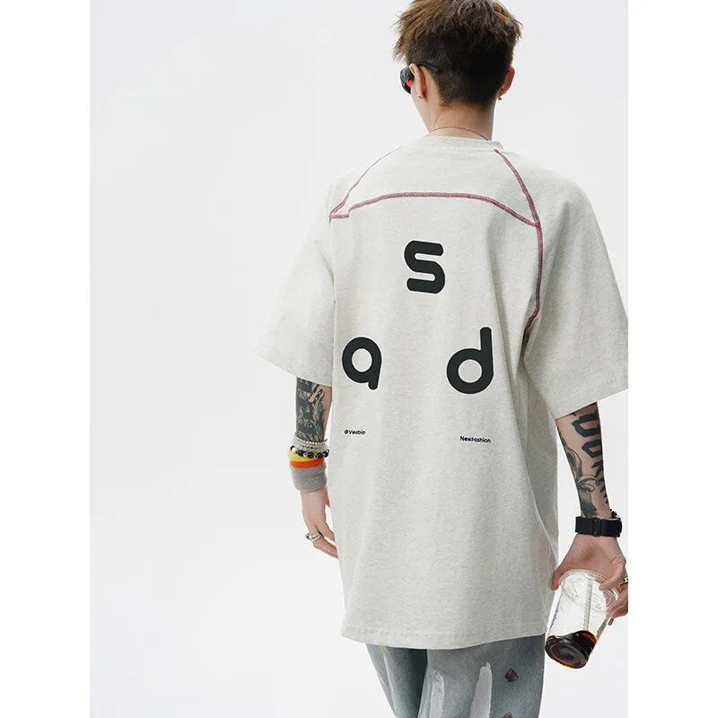 A loose-fitting black cotton short-sleeve T-shirt with a round neck on a hanger.
