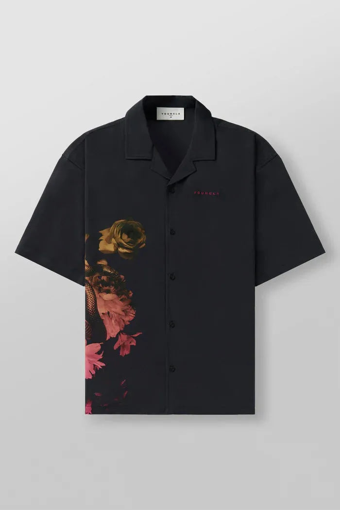 Man wearing a loose-fit, short sleeve floral print top in a neutral colour.