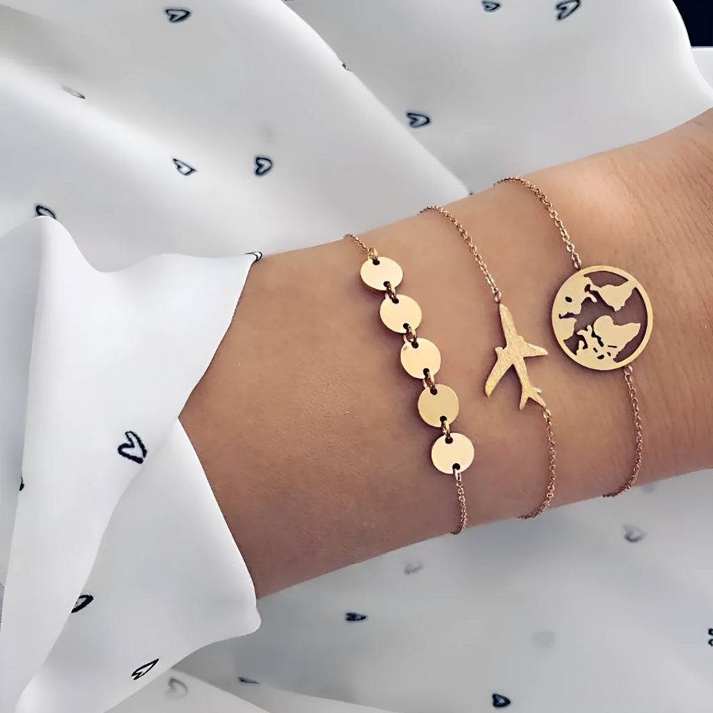 Three bohemian-style alloy bracelets with heart-shaped aircraft map charms on a white background.
