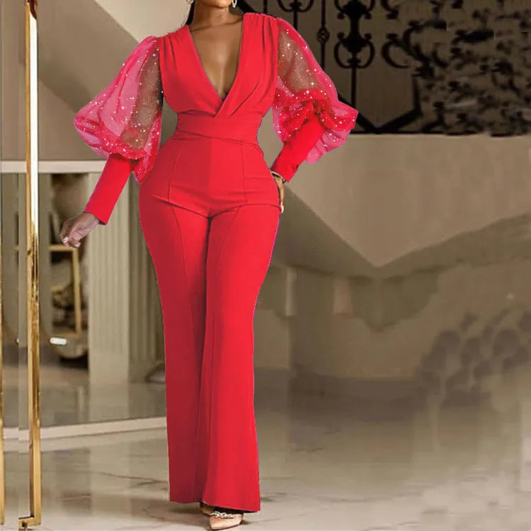Red women's long sleeve jumpsuit with mesh stitching detail, elastic waist, and wide leg trousers.