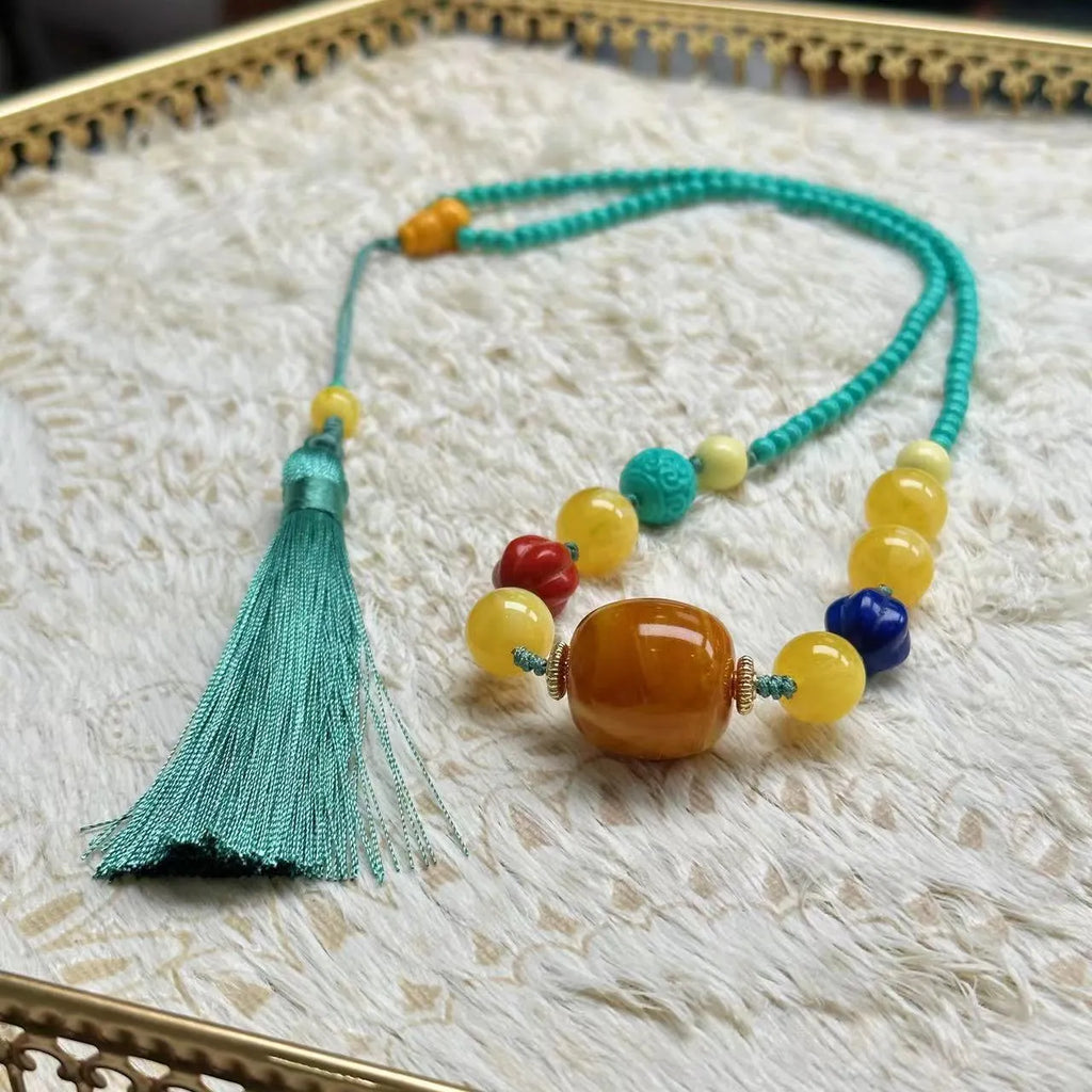 Turquoise stone pendant with hand-woven mesh flower design on a ball bead necklace chain.