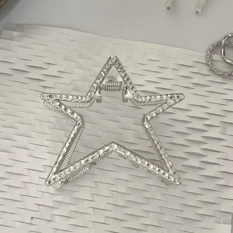 Silver metal hair claw clip assortment showing bows, waves, pearl designs, and geometric shapes from 4cm to 13.5cm