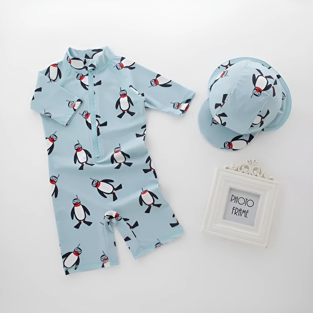 Blue boys two-piece penguin swimsuit with long sleeves and a matching swim cap.