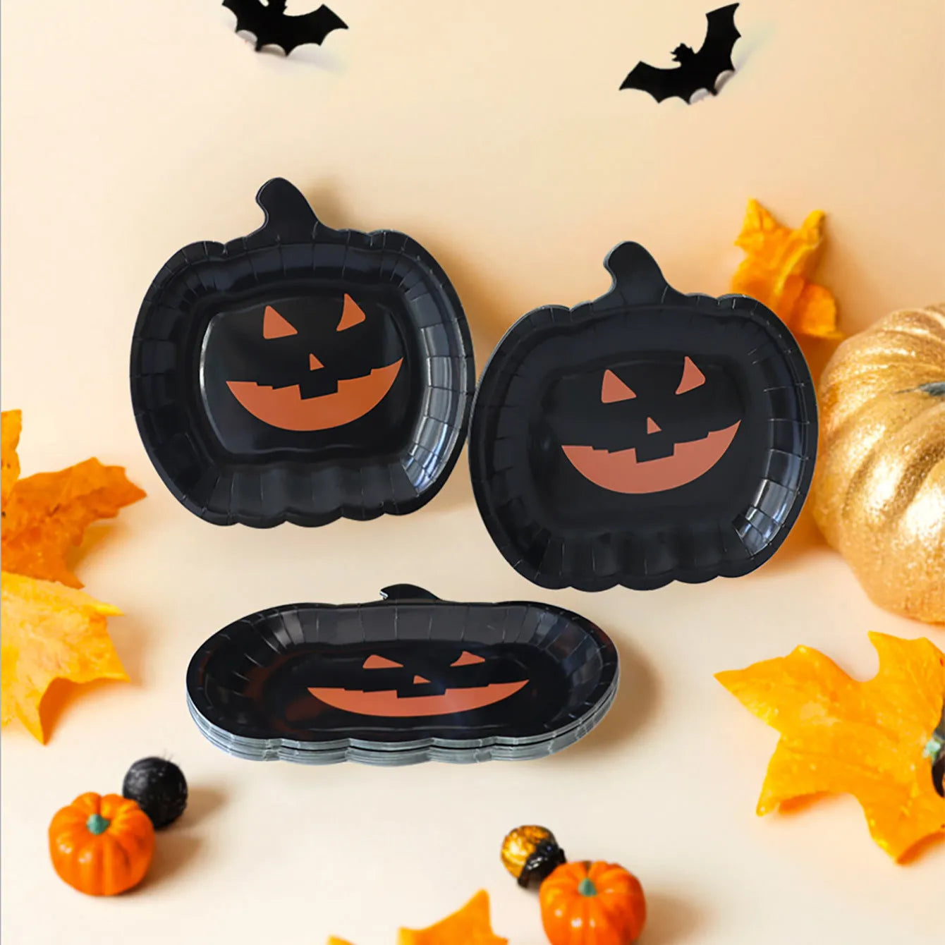 Set of black disposable Halloween paper plates with orange pumpkin design, 9 inches in diameter.