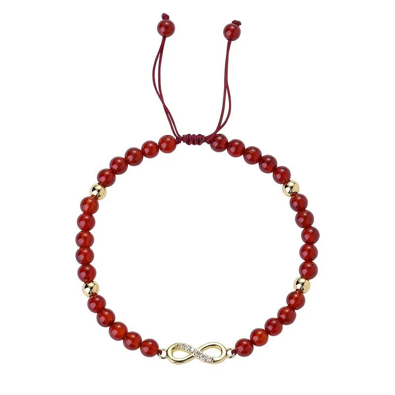 Hand-woven red agate bead bracelet with ethnic design on a wrist.