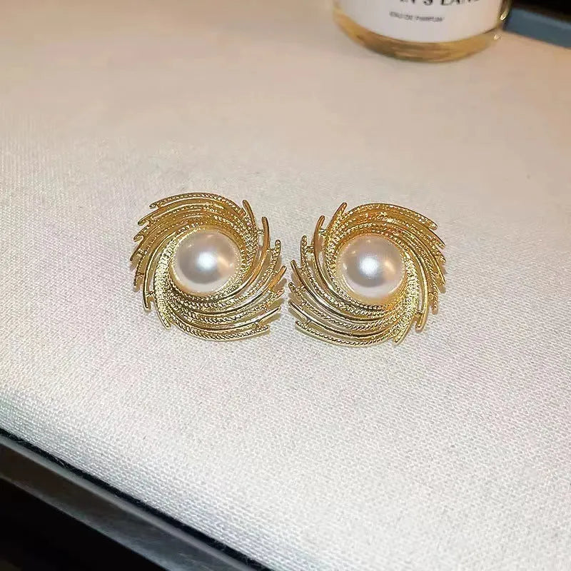 A pair of vintage-style alloy flower earrings with pearl-coloured details and an irregular shape.