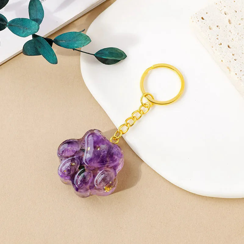 Natural crystal cat's paw shaped pendant on a silver keychain ring, shown in a random colour.
