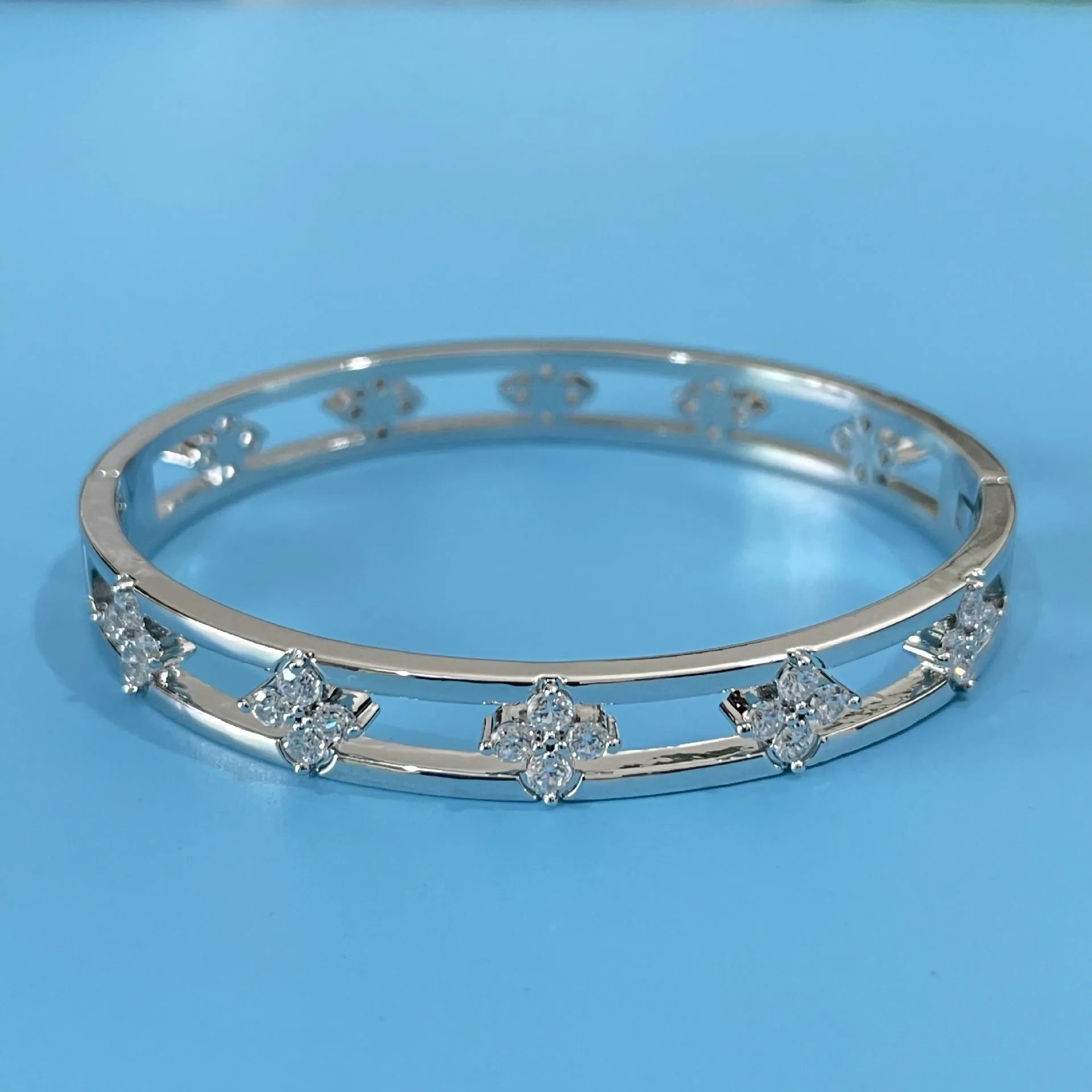 Women's hollow bracelet with four-leaf clover charm and zircon stones in gold or silver