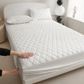 Diamond lattice quilted waterproof mattress protector in bamboo fibre shown on bed