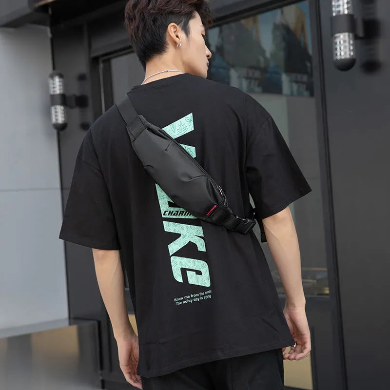 Black Oxford cloth crossbody waist pack showing front zipper and strap