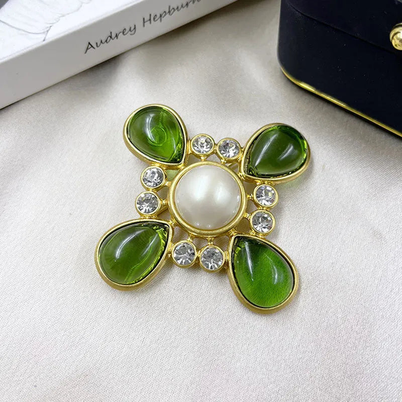 Close-up of vintage medieval baroque cross brooch with crystal details on zinc alloy base