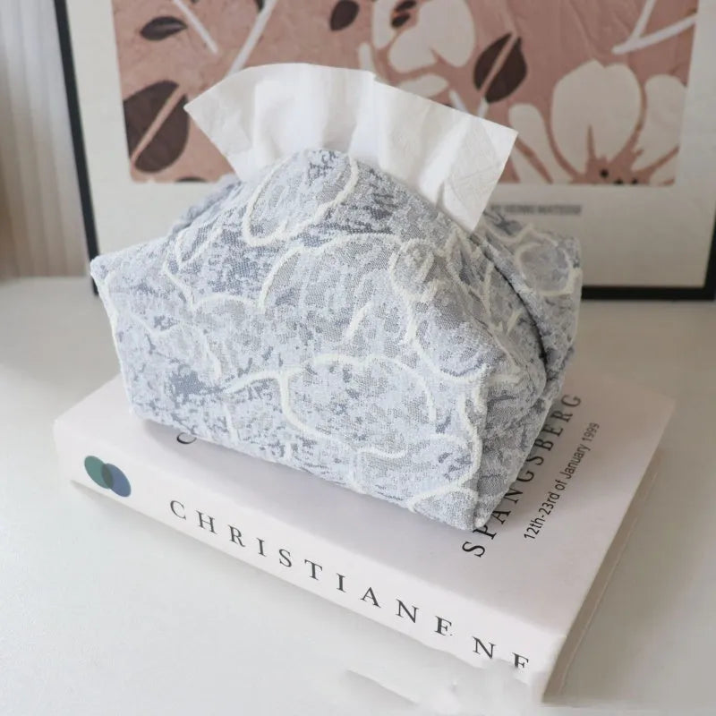 Handmade beige rose patterned cotton fabric tissue box cover on a wooden table.