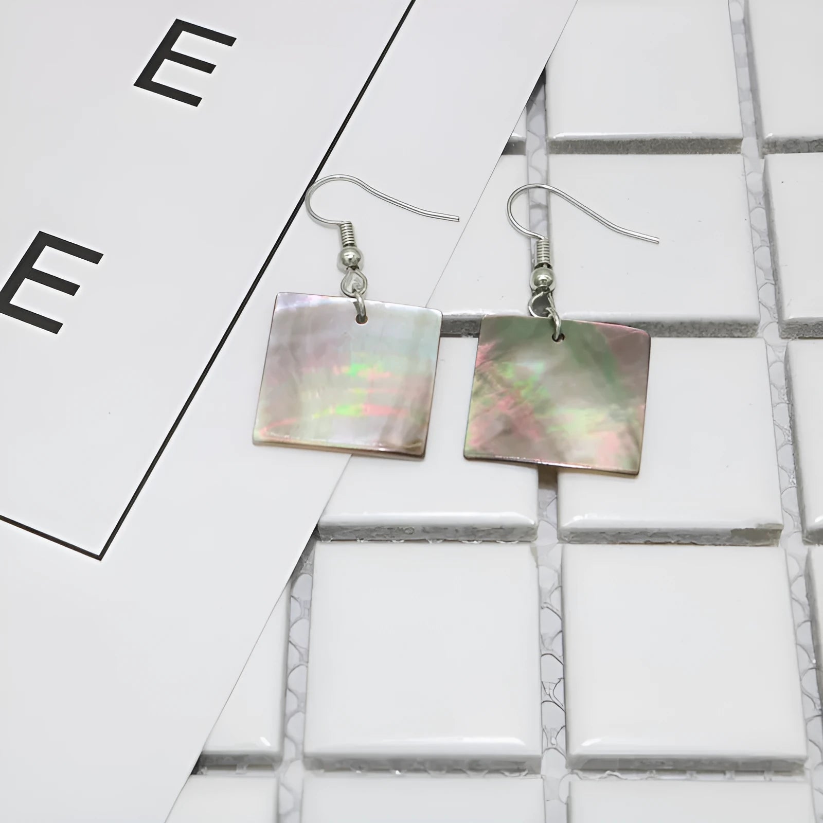 Women's geometric shell earrings in square panther or rectangular shell designs with natural material texture