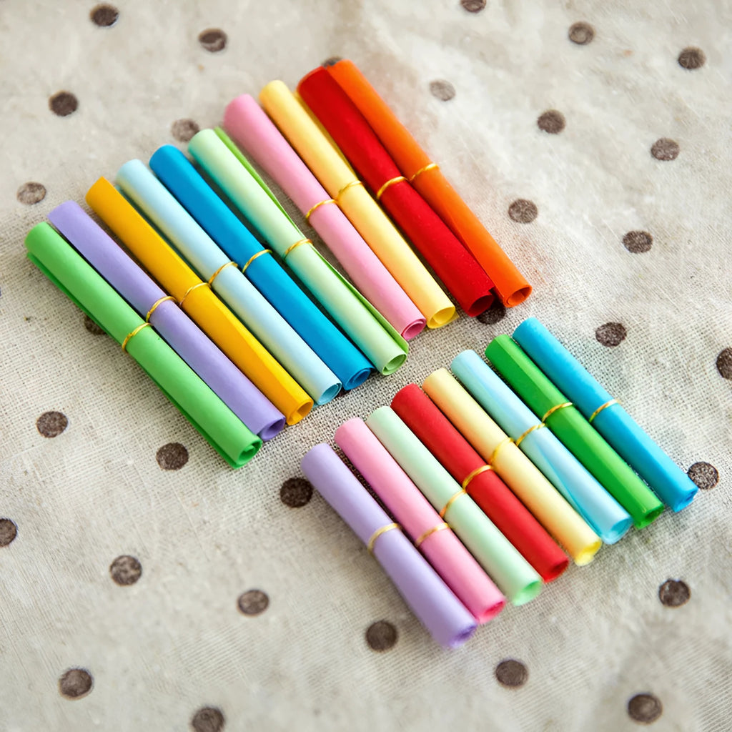 Assorted colour mini paper scrolls with punched holes for drift bottle notes and crafts.