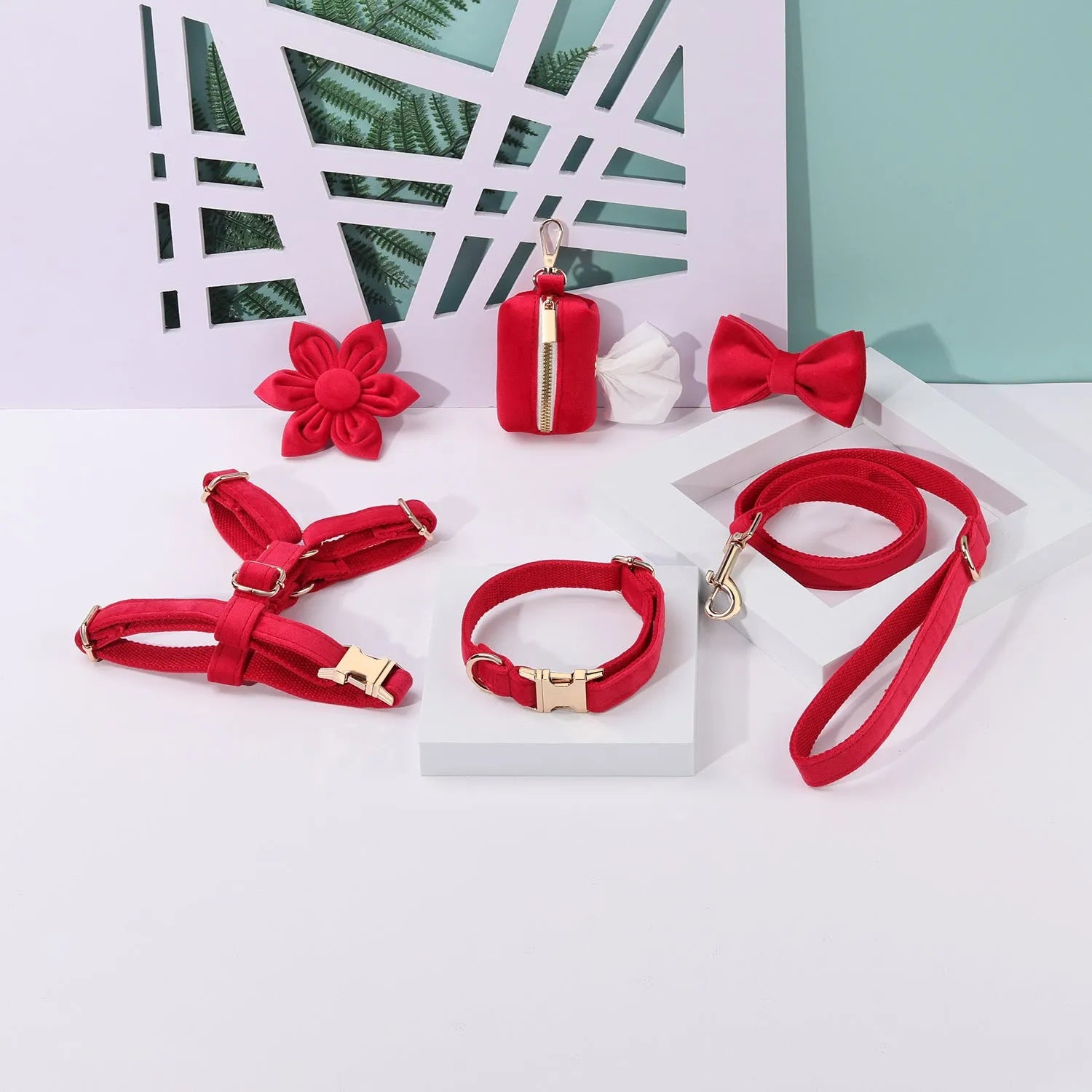Red velvet dog collar and leash set with chest strap, bow tie, and decorative flower accessories.