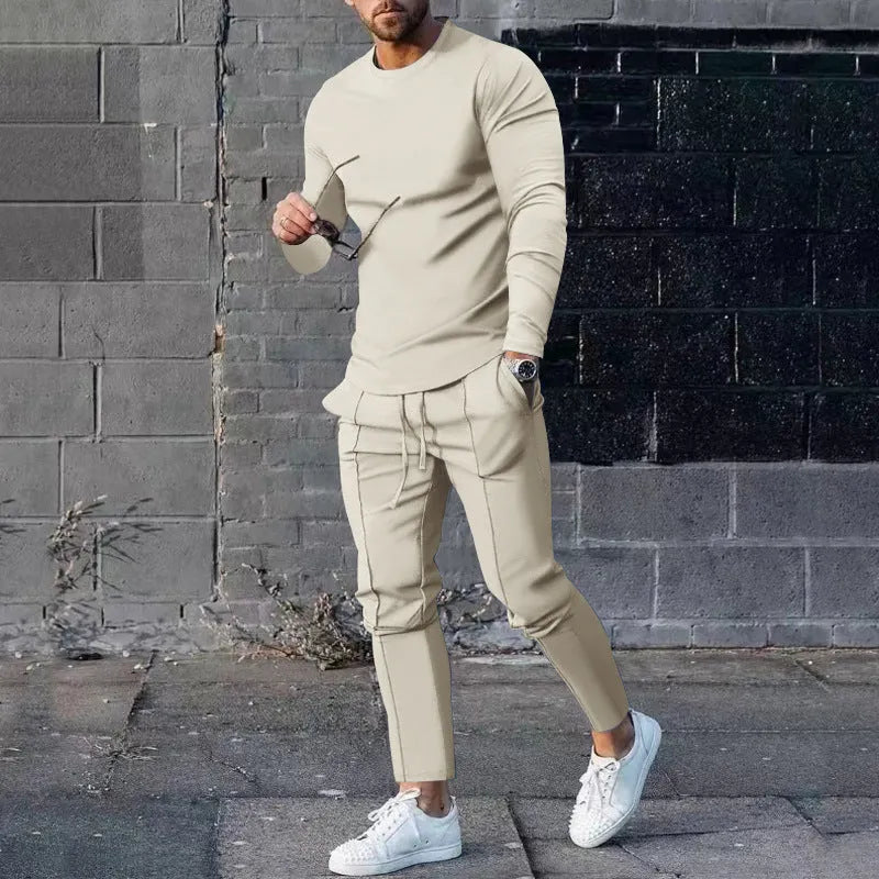 Men's light grey polyester two-piece suit with long sleeve round neck T-shirt and matching trousers laid flat.