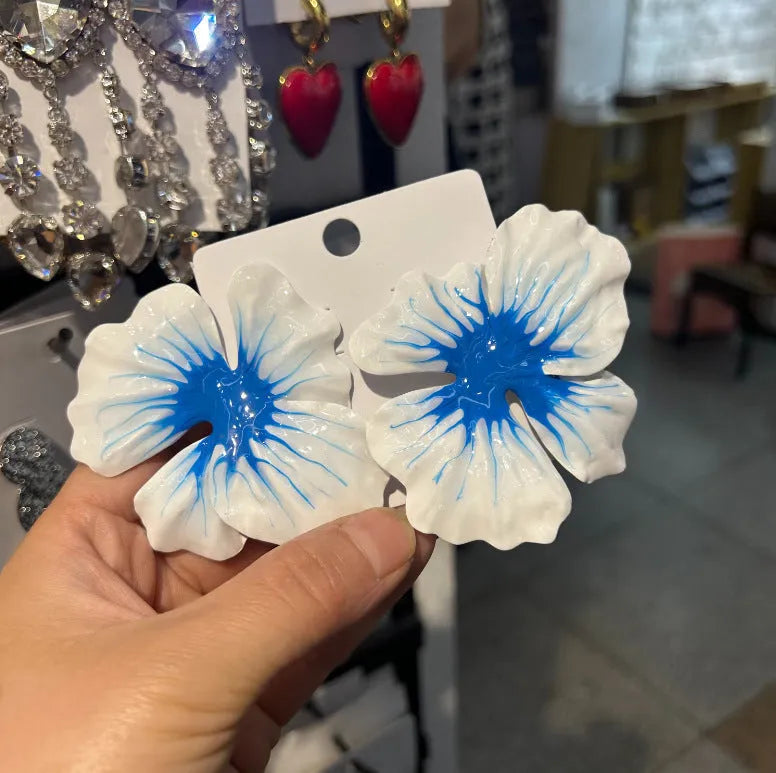 Close-up of women's alloy flower stud earrings with a blue oil-spot glaze and electroplated finish.