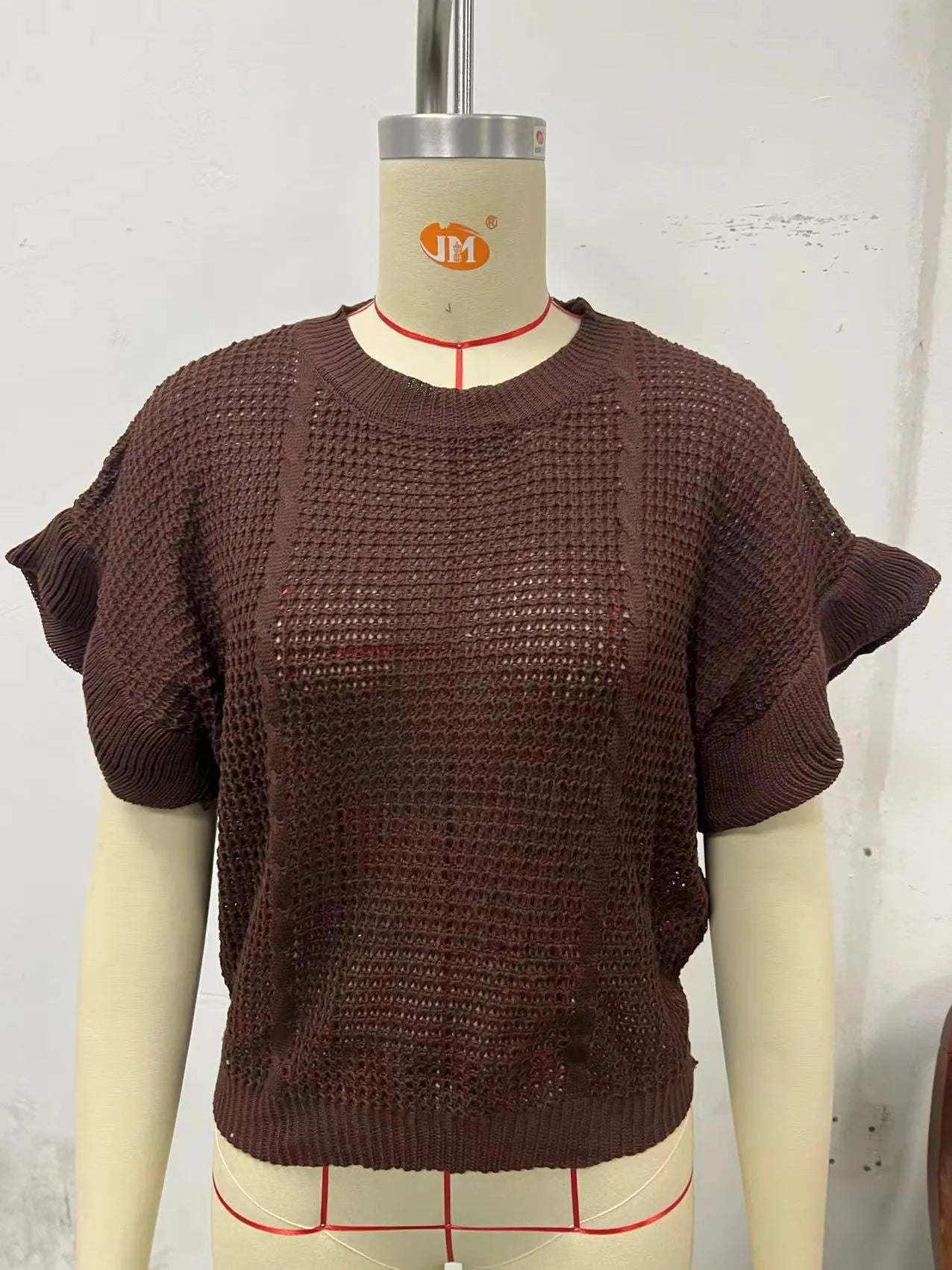 Twisted string detail and ruffled short sleeves on a loose-fit round neck knitted pullover sweater.