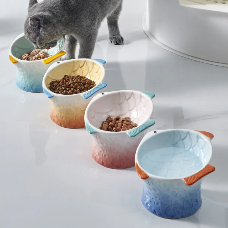 Blue fish-shaped ceramic elevated cat bowl with tilted design on a non-slip base.