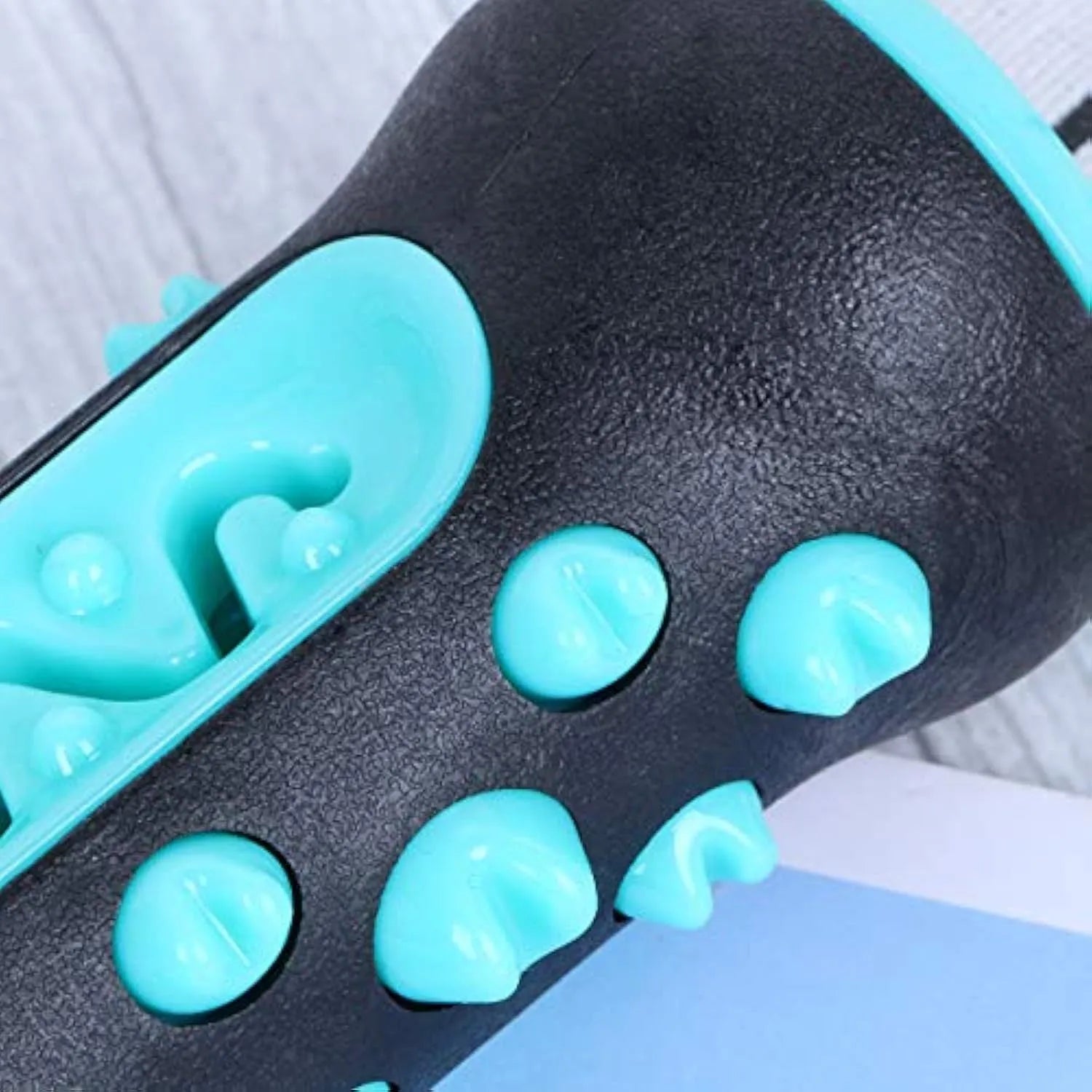 A blue natural rubber dog toothbrush chew toy with a textured surface, shown next to a green one.