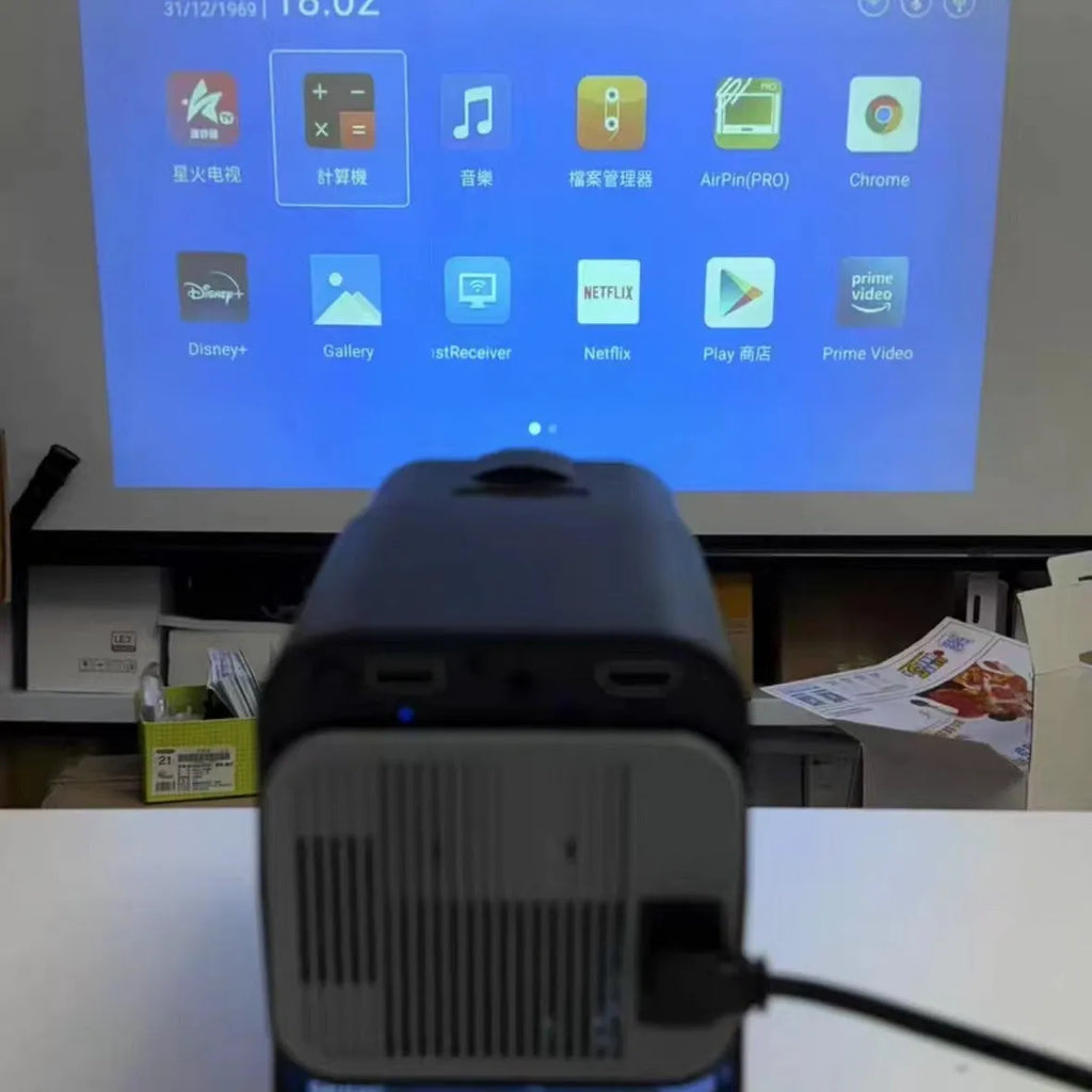 White portable home projector with handle showing 720p wireless gaming setup