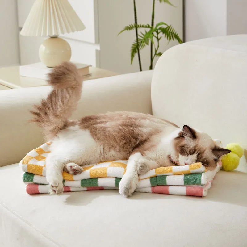 Plaid pattern pet blanket with fur ball trim on soft cotton fleece material for cats and dogs