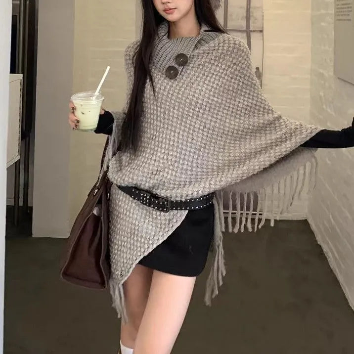 Women's triangular plush shawl cape with tassels in a cashmere and acrylic blend fabric.